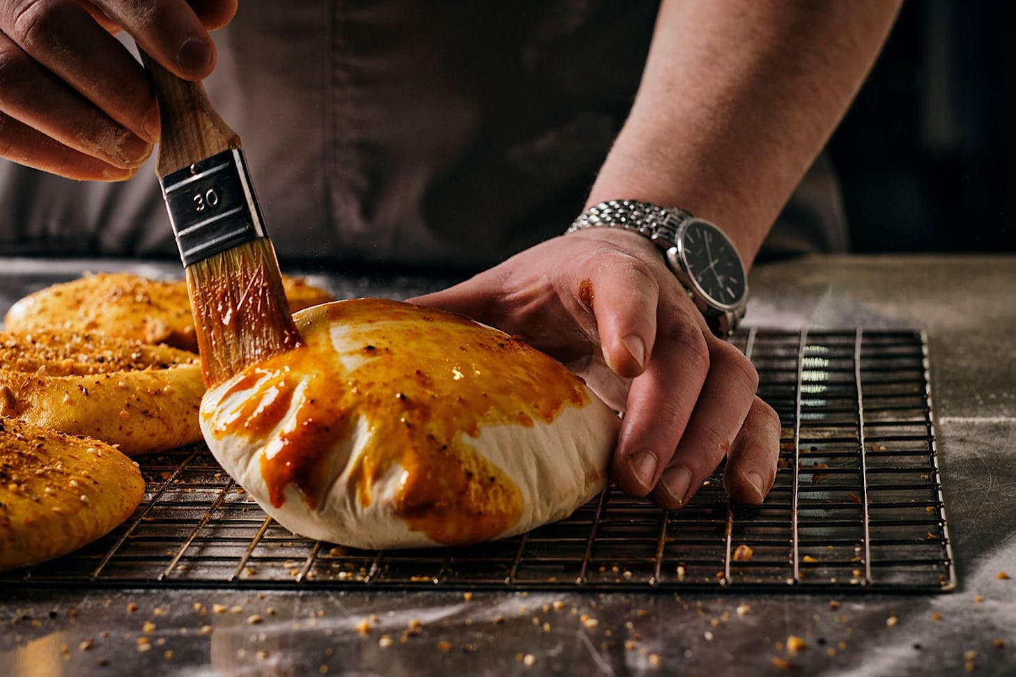 A chef at Advieh glazes a pita bread